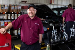 Jiffy Lube Technician Standing in front of black jeep