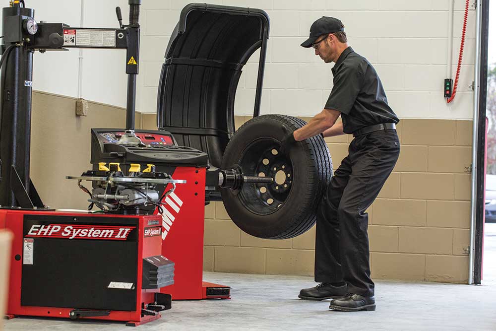 Jiffy Lube Technician using computerized wheel balancing machine