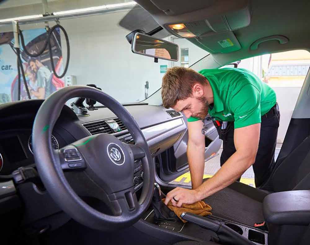 man cleaning interior of vehicle